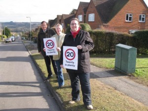Martin Tod, Phryn Dickens and Rose Prowse standing on Battery Hill with 20 mph signs