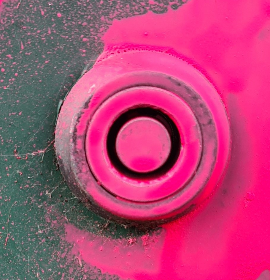 Close up photograph of a keyhole on an Virgin Media cabinet covered in graffiti paint that takes a conventional round key
